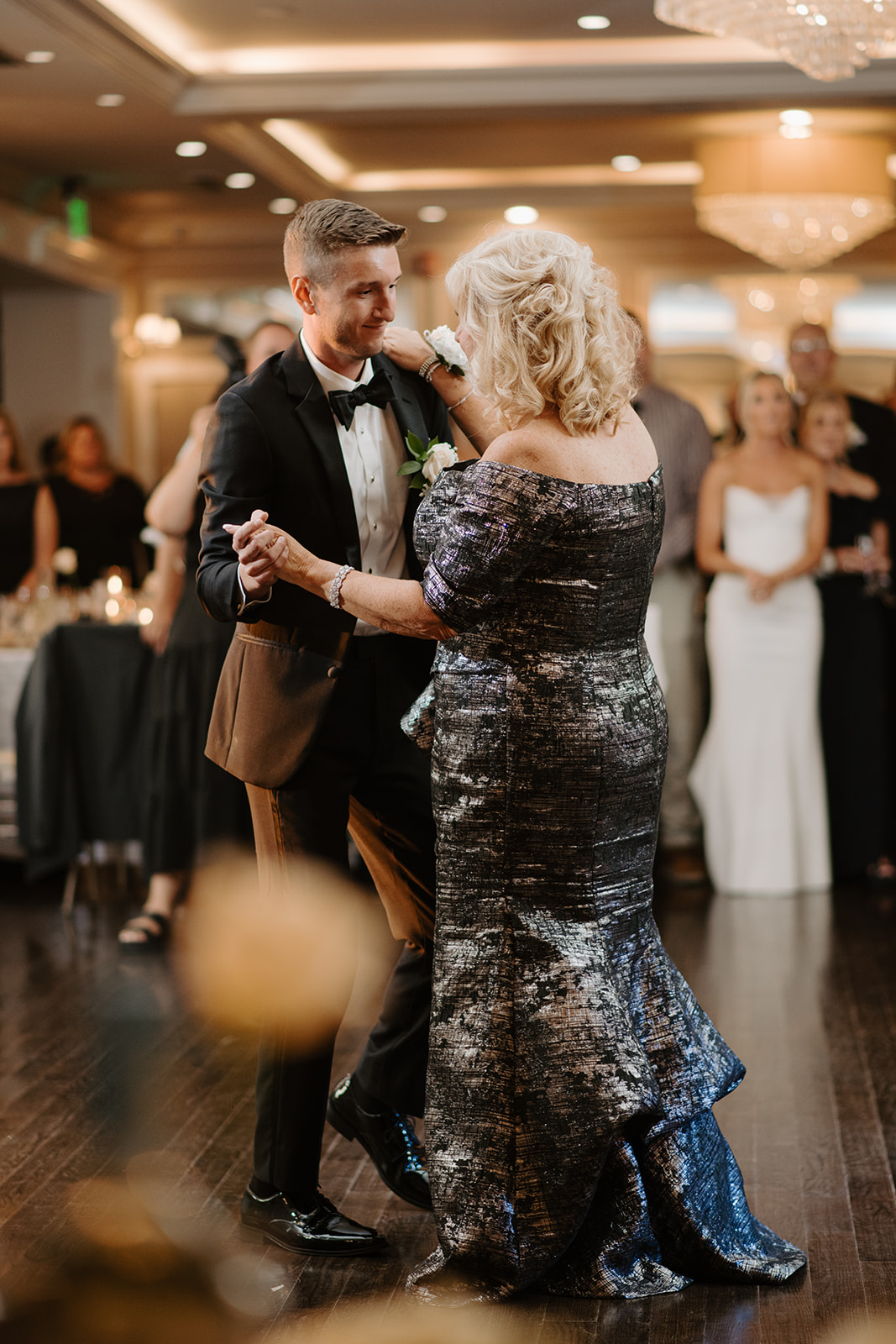 Groom dances lovingly with his mother during the reception, sharing a sweet and emotional moment.